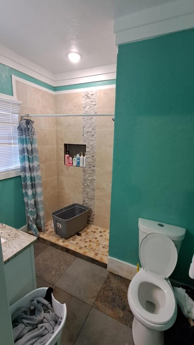 bathroom with toilet, a stall shower, and vanity