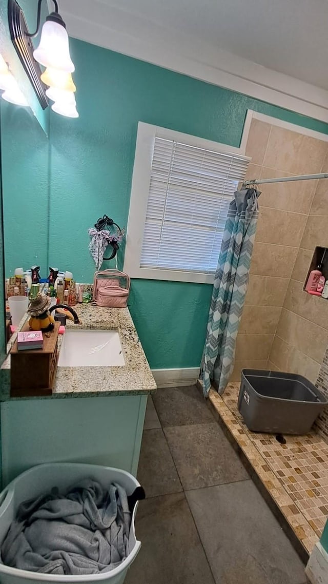 bathroom featuring a shower stall, tile patterned flooring, baseboards, and vanity