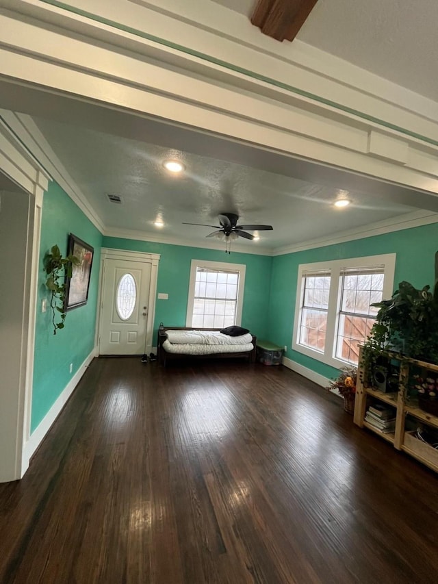 interior space with a ceiling fan, dark wood finished floors, crown molding, and baseboards