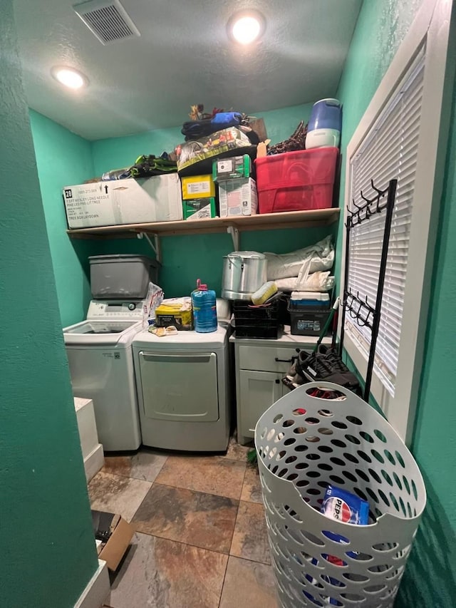 washroom featuring laundry area, washing machine and dryer, and visible vents