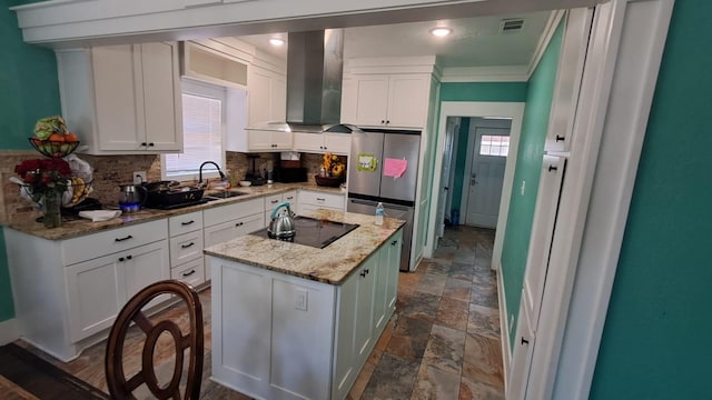 kitchen featuring a center island, freestanding refrigerator, white cabinets, and extractor fan