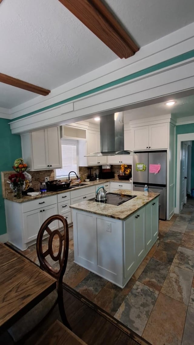 kitchen featuring extractor fan, white cabinetry, freestanding refrigerator, stone finish flooring, and an island with sink