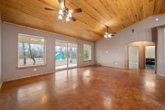 unfurnished living room featuring arched walkways, finished concrete flooring, wood ceiling, vaulted ceiling, and baseboards