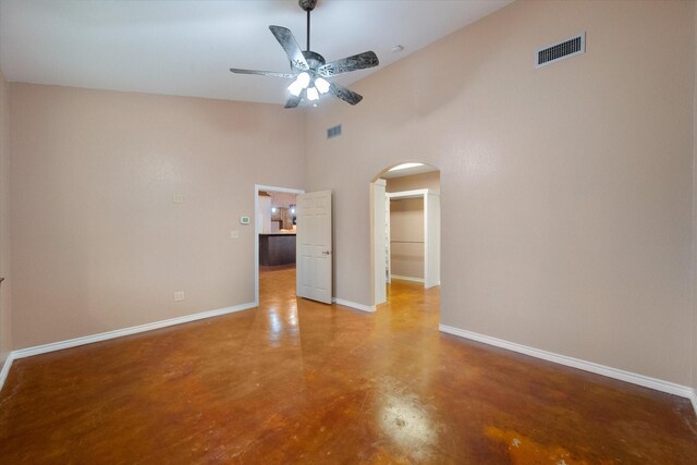 spare room with ceiling fan, baseboards, vaulted ceiling, and unfinished concrete flooring