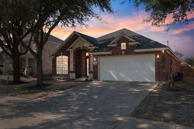 view of front facade with a garage, central AC unit, concrete driveway, and brick siding