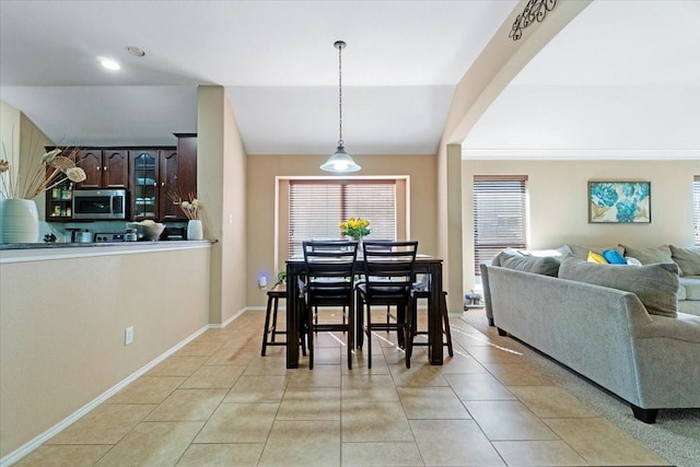 dining room with lofted ceiling, light tile patterned floors, and baseboards