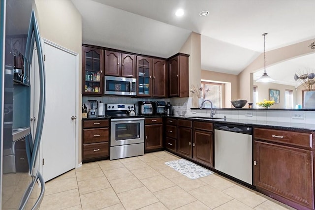 kitchen featuring stainless steel appliances, hanging light fixtures, glass insert cabinets, dark brown cabinetry, and a sink