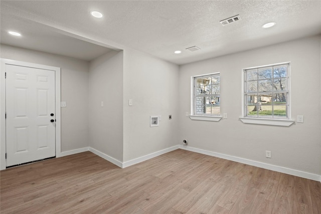 clothes washing area with hookup for a washing machine, laundry area, visible vents, light wood-style floors, and electric dryer hookup