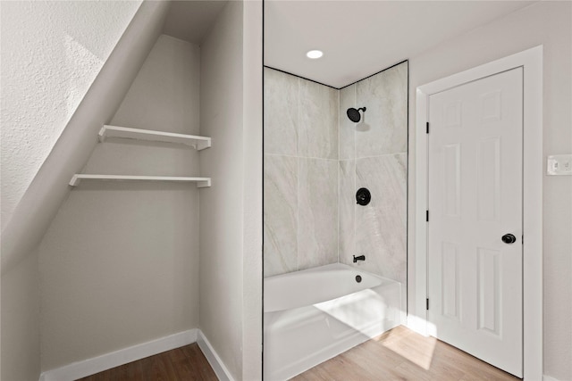 bathroom with shower / bath combination, baseboards, and wood finished floors