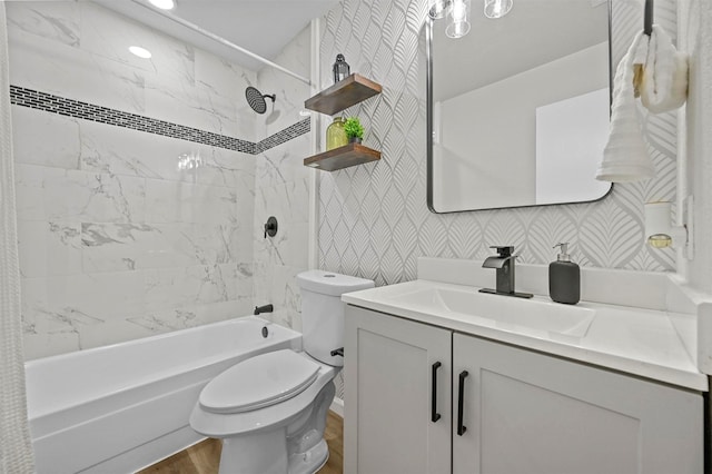 full bath featuring shower / bathtub combination, toilet, vanity, wood finished floors, and wallpapered walls