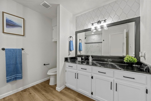 full bath with a marble finish shower, visible vents, baseboards, toilet, and wood finished floors