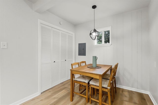 dining space with electric panel, baseboards, and wood finished floors