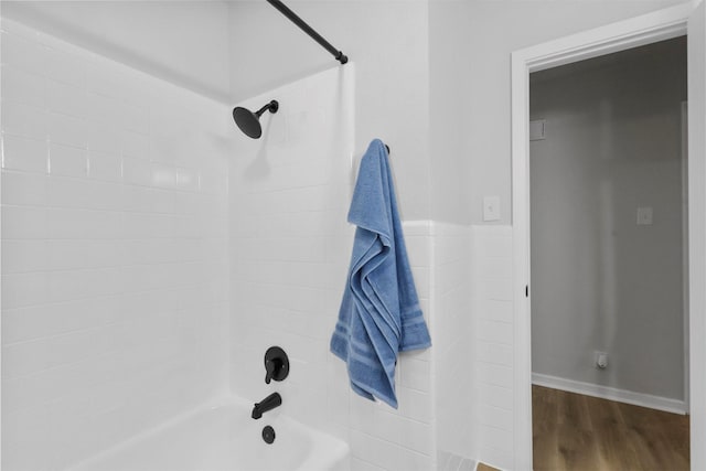 full bath with shower / bath combination, baseboards, and wood finished floors