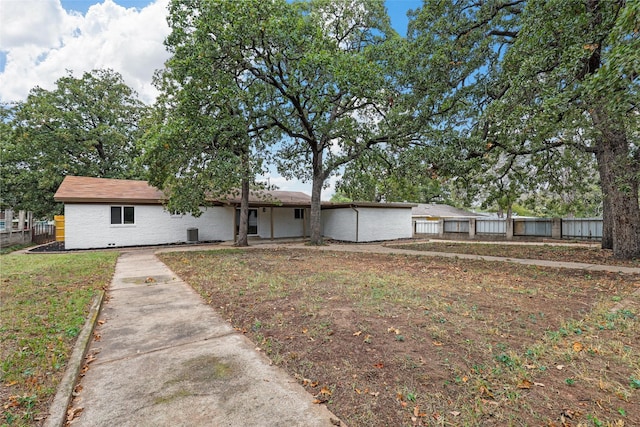 ranch-style house with a front yard and fence