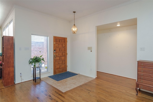 foyer featuring ornamental molding and wood finished floors