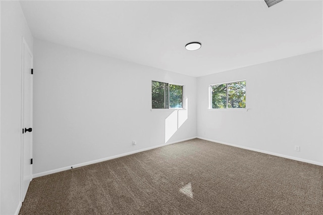 carpeted empty room featuring baseboards