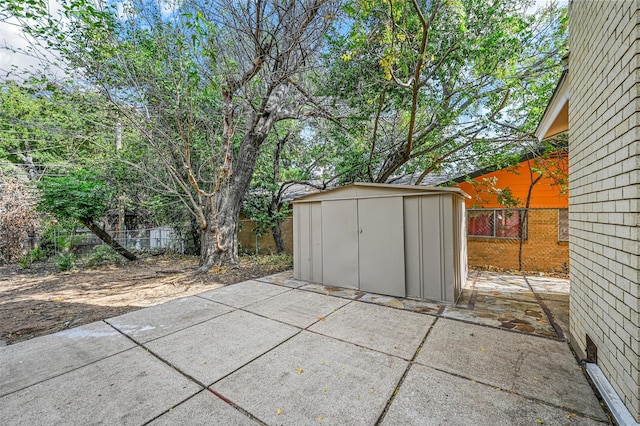 view of patio / terrace with an outbuilding, a fenced backyard, and a storage unit