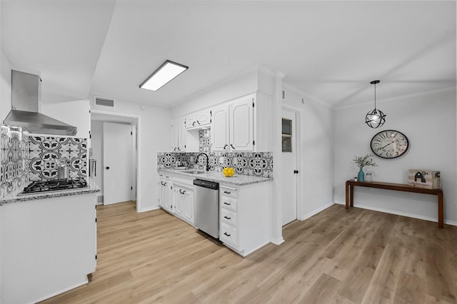 kitchen with a sink, visible vents, white cabinets, appliances with stainless steel finishes, and wall chimney exhaust hood