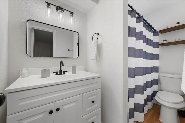 full bath with toilet, a shower with curtain, wood finished floors, and vanity