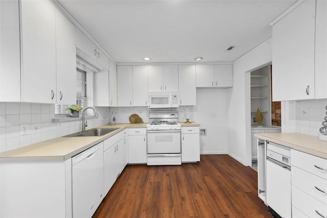 kitchen with tasteful backsplash, light countertops, white cabinetry, a sink, and white appliances