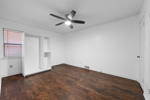 unfurnished bedroom with a ceiling fan, dark wood finished floors, visible vents, and baseboards