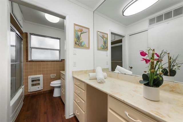 bathroom featuring toilet, tile walls, vanity, visible vents, and heating unit