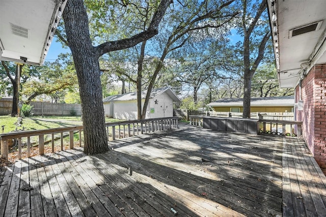 wooden deck featuring a fenced backyard and a lawn