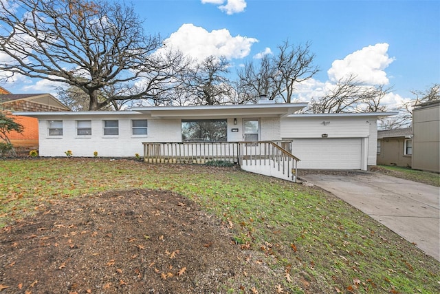 ranch-style house with brick siding, a chimney, concrete driveway, an attached garage, and a front yard