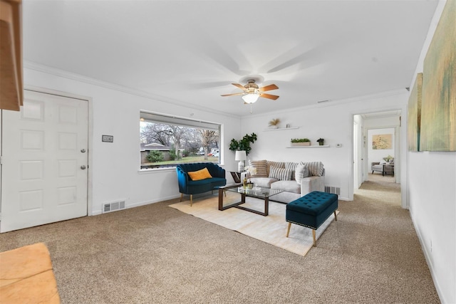 living area with a ceiling fan, visible vents, carpet flooring, and ornamental molding