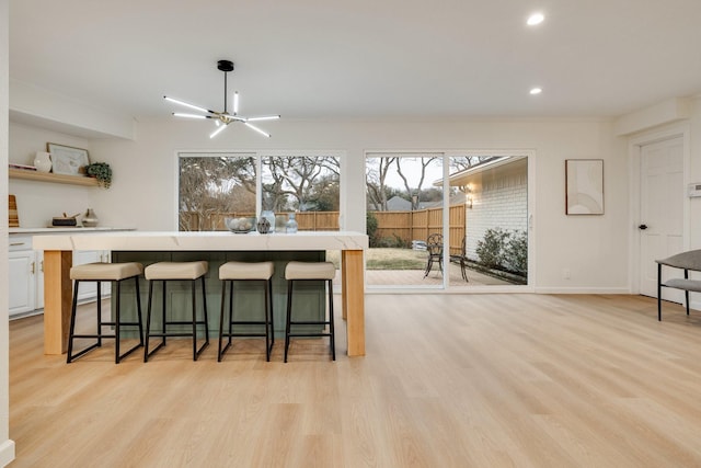 kitchen featuring a breakfast bar, light wood-style flooring, and light countertops