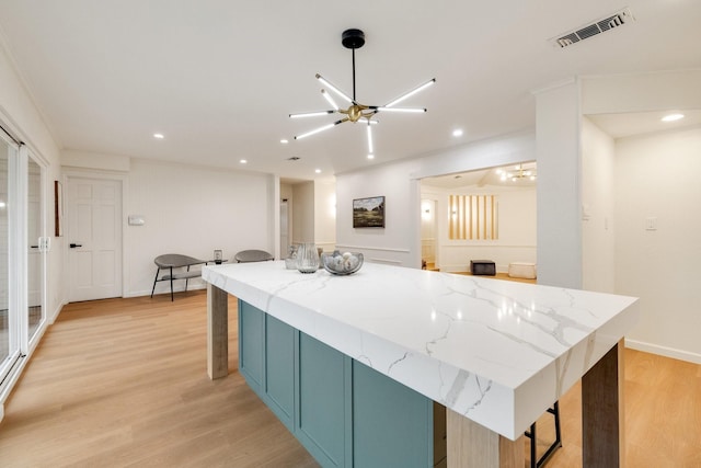 kitchen with light stone counters, light wood-style flooring, visible vents, and recessed lighting