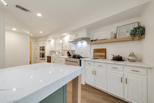 kitchen featuring white cabinetry, visible vents, under cabinet range hood, and open shelves