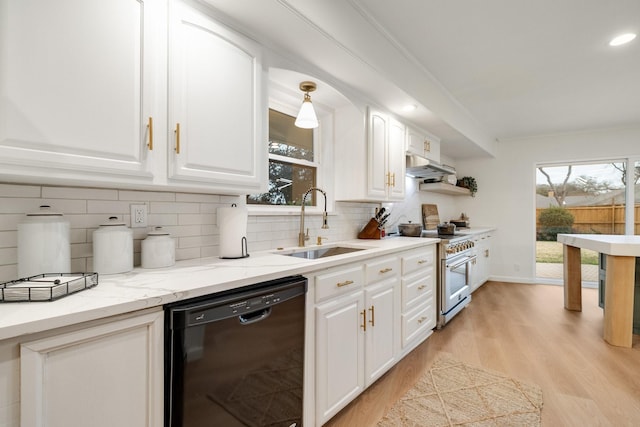 kitchen with high end stove, a sink, white cabinetry, dishwasher, and decorative light fixtures