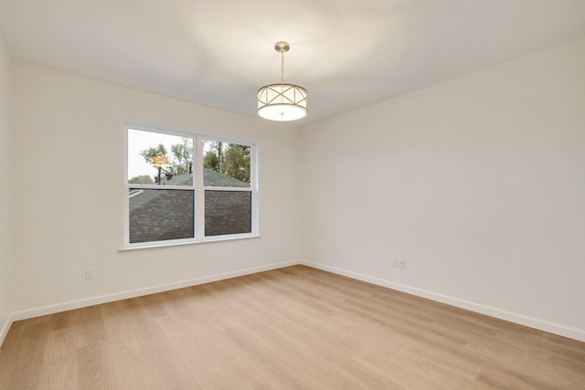 spare room featuring light wood-style floors and baseboards