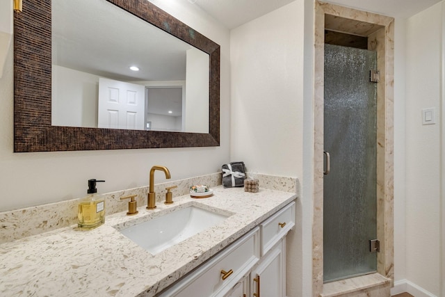 bathroom with a stall shower, vanity, and recessed lighting