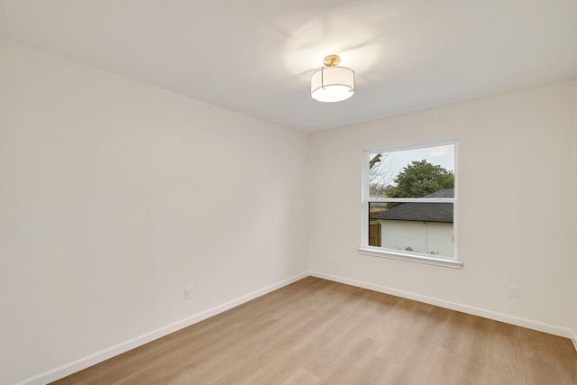 empty room featuring baseboards and light wood finished floors