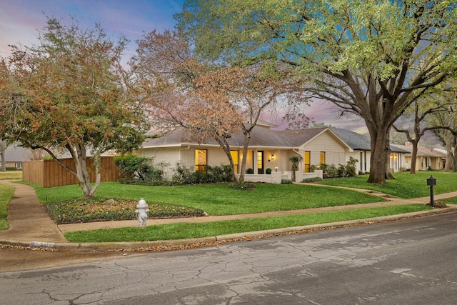 view of front facade featuring brick siding, a front yard, and fence