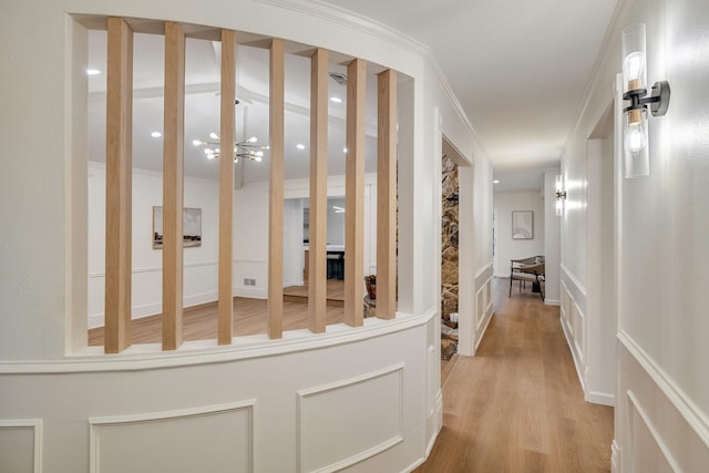 hallway featuring ornamental molding, visible vents, and light wood finished floors