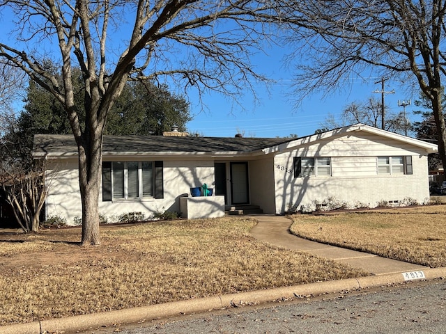 single story home featuring a front yard and brick siding