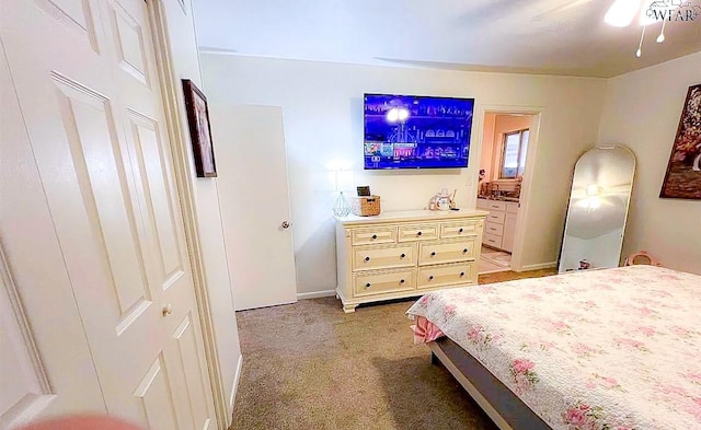 bedroom featuring light colored carpet and connected bathroom