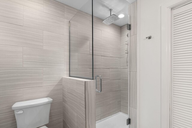 bathroom featuring tile patterned floors, toilet, and tile walls