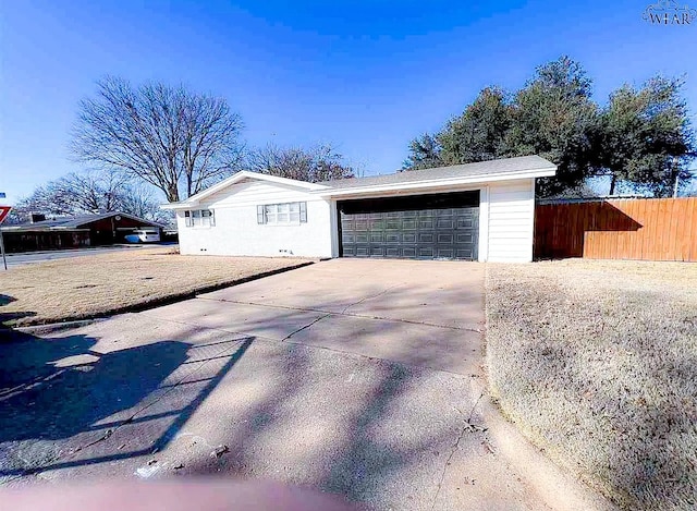 garage featuring fence and driveway