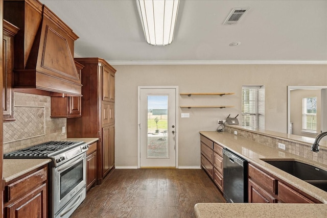 kitchen featuring stainless steel appliances, premium range hood, a sink, visible vents, and dark wood-style floors