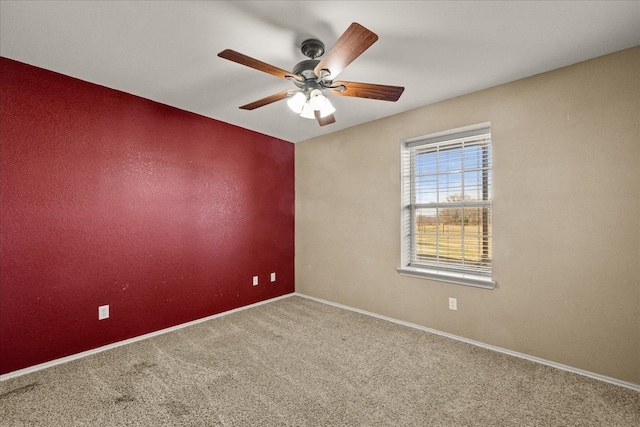 unfurnished room with a ceiling fan, carpet flooring, and baseboards