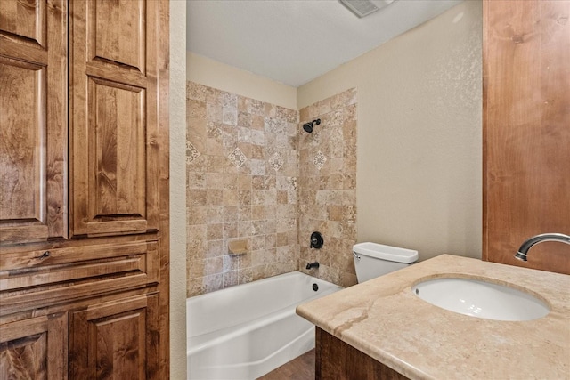 bathroom featuring visible vents, a textured wall, toilet, vanity, and shower / washtub combination