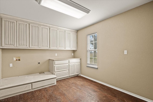 clothes washing area featuring washer hookup, cabinet space, electric dryer hookup, wood finished floors, and baseboards