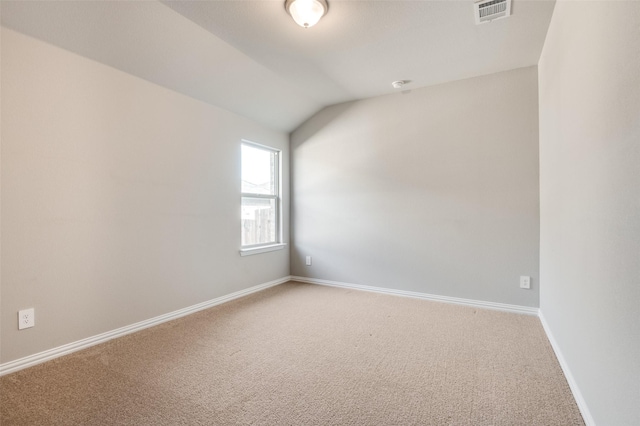 unfurnished room with lofted ceiling, baseboards, visible vents, and carpet flooring