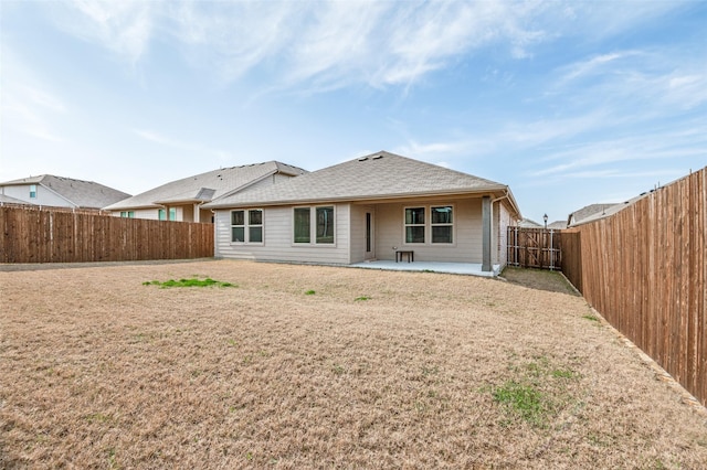 rear view of house with a patio area, a fenced backyard, and roof with shingles