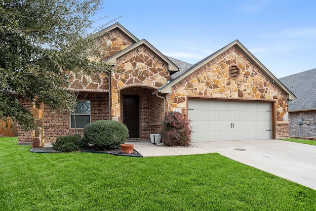 view of front of house with an attached garage, concrete driveway, a front lawn, stone siding, and brick siding