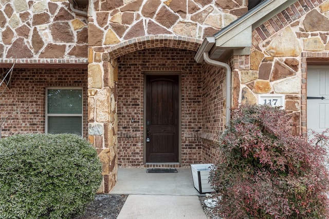 entrance to property with stone siding and brick siding